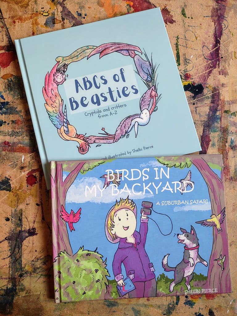 A hardcover copy of my book ABCs of Beasties and Birds in My Backyard: A Suburban Safari rest on a painted background. 